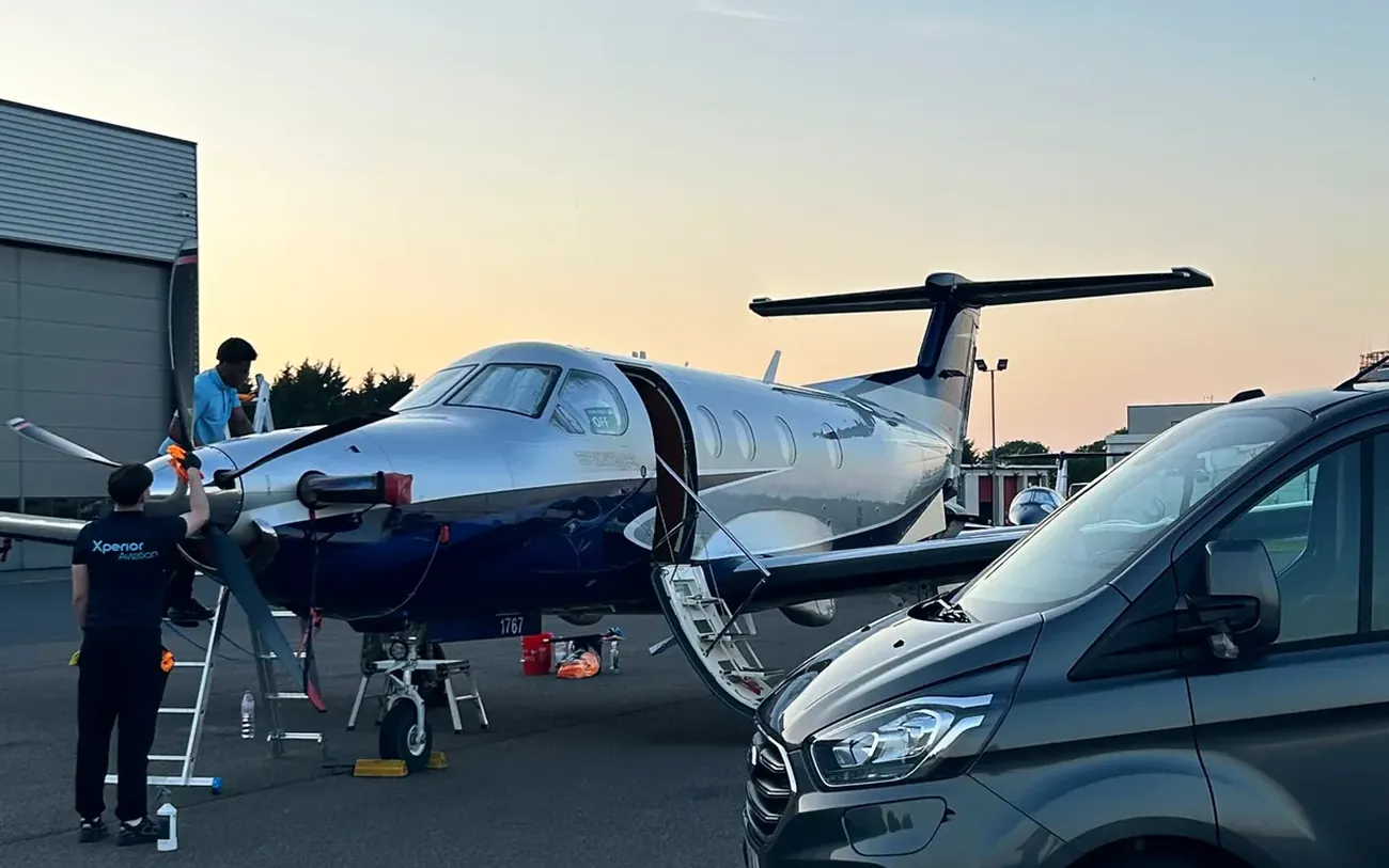 Detailing crew working on an aircraft at dusk after a maintenance visit