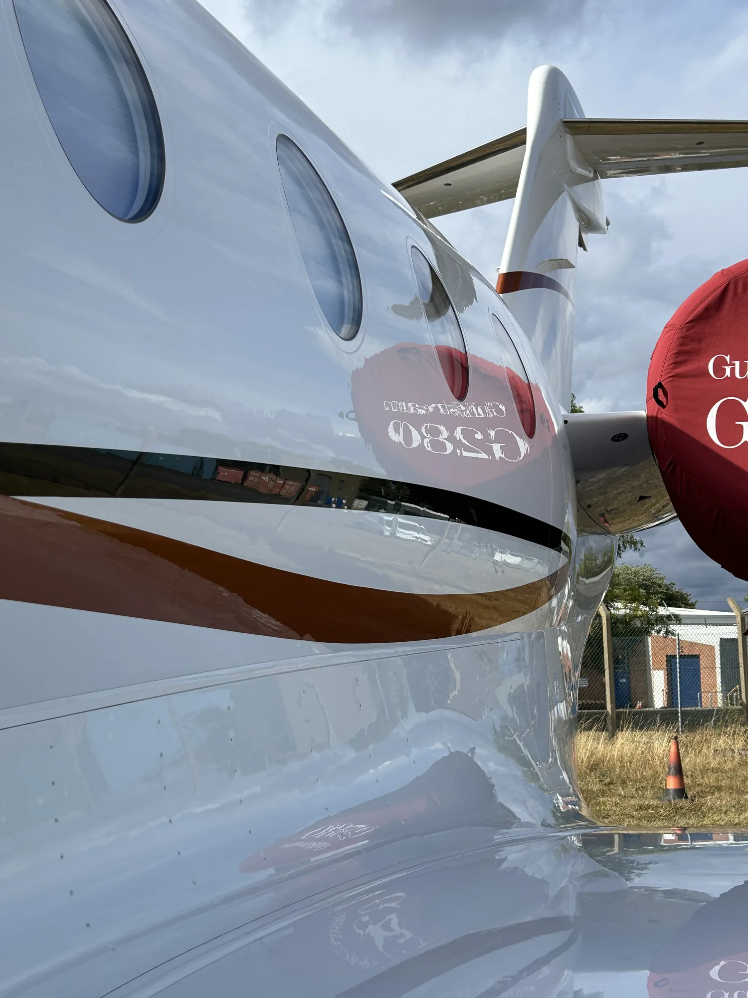 Polished private jet fuselage reflecting the engine nacelle after ceramic coating