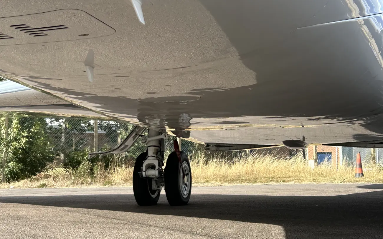 The same private jet belly after cleaning, the paintwork restored to a reflective gloss finish