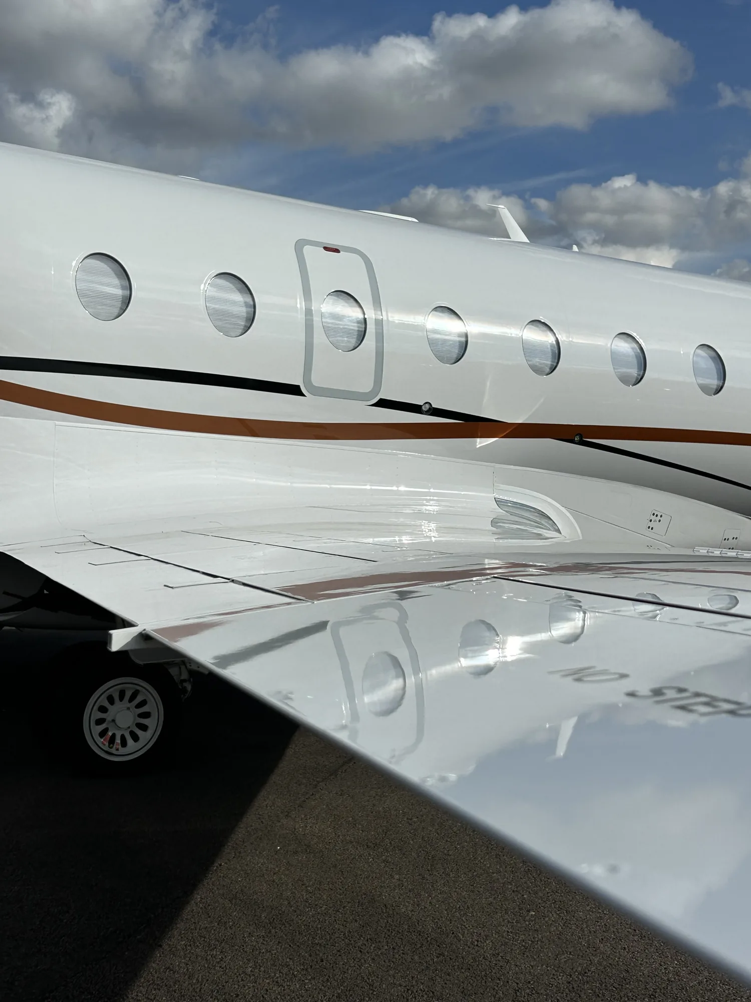 Cabin windows and polished wing of a private jet after exterior detailing
