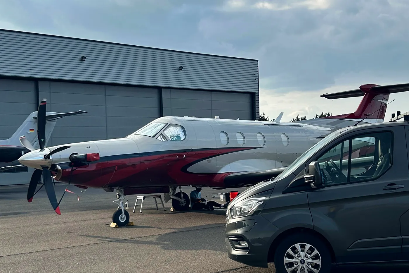 Red and white turboprop parked at Biggin Hill during an exterior aircraft clean