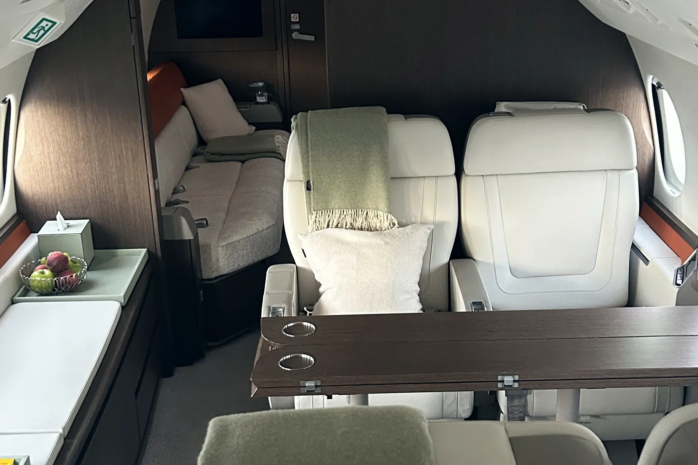 Private jet cabin with cream leather seating and polished veneer after a full interior detail